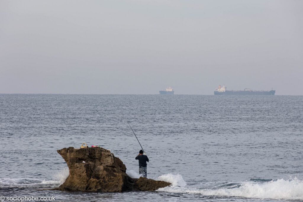 Fishing on the ruined Crusader foundations of the sea walls at Acre